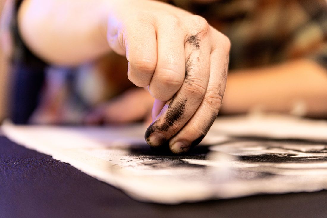 James Thomas drawing a charcoal portrait with dusty fingers
